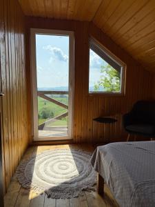 a bedroom with a bed and a window with a view at Panoramic House in Mărişel