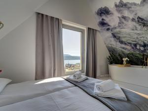 a bedroom with a large window with towels on a bed at Apartament Panorama Lake & Ski in Kluszkowce