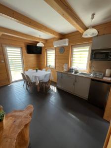 a kitchen with a white table in a wooden room at Apartamenty Jaworzynka in Jaworzynka