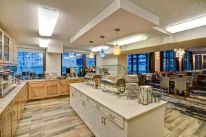 芝加哥Homewood Suites by Hilton Chicago-Downtown的大型厨房设有木制橱柜、桌子和窗户。