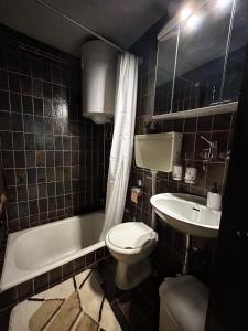 a bathroom with a white toilet and a sink at Šumska Bajka in Orahovica +16 photos