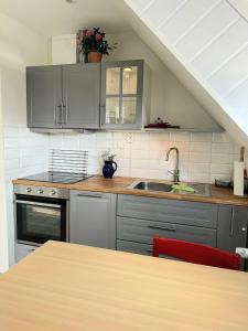 a kitchen with gray cabinets and a sink and a table at Haus Ostwind - Wohnung 2 in Dahme