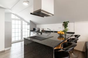 een keuken met een aanrecht met zwarte stoelen bij Barreiro View in Ribeira Brava