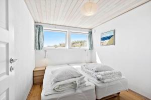 two beds in a room with a window at 503-Hvide-Sande-Sonder-Klitvej-129 in Havrvig