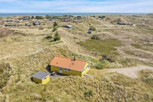 an overhead view of a small yellow house in a field at 503-Hvide-Sande-Sonder-Klitvej-129 in Havrvig