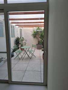 a sliding glass door with a patio with chairs and a table at Casa Maria in Żabbar