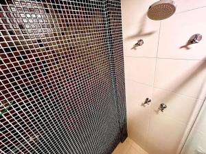 a bathroom with a shower with black and white tiles at PRAIA Mar Sofisticado Novo in Vila Velha