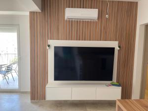 a living room with a large television on a wall at MBv Budva in Budva