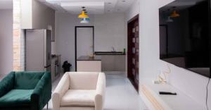 a living room with a couch and a chair and a kitchen at Kuwunda Apartments in Lusaka