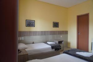 two beds in a room with yellow walls at Hotel Premium Uruçuí in Uruçuí +25 photos