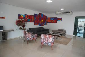a living room with a couch and two chairs at Hotel Premium Uruçuí in Uruçuí