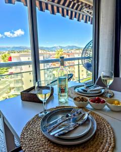 a table with plates and wine glasses on a balcony at Beachfront - Panoramic View - Balkony - AC in Cagnes-sur-Mer