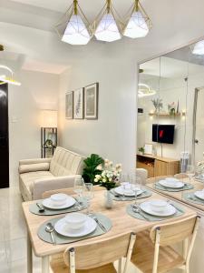 ein Wohnzimmer mit einem Tisch und einem Sofa in der Unterkunft Cozy 2BR Stay for 6pax in High-Floor, Wi-Fi & Family Games near IT Park Cebu- Unit Scarlett by GERRA in Mandaue City + 19 Fotos