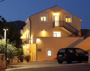 a car parked in front of a house at night at Bacan Serviced Apartments in Cavtat