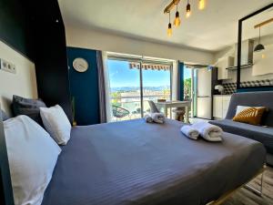 a bedroom with a large bed with towels on it at Beachfront - Panoramic View - Balkony - AC in Cagnes-sur-Mer