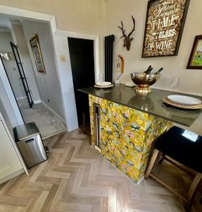 a kitchen with a counter with a colorful island at Olive Tree Cottage in Golcar
