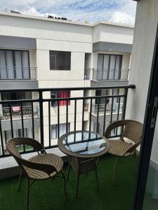 a patio with chairs and a glass table on a balcony at Homely Stays, Ruaka in Nairobi