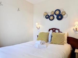 een slaapkamer met een bed met handdoeken erop bij L'Escale à Deauville in Deauville +24 foto's