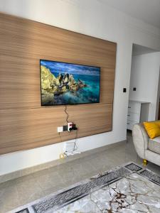 a living room with a tv on a wall at Homely Stays, Ruaka in Nairobi