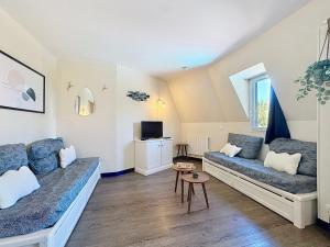 een woonkamer met een bank en een tv bij L'Escale à Deauville in Deauville