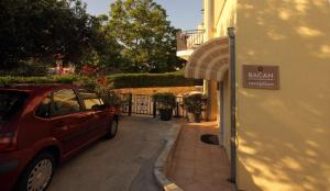 a red car parked in front of a building at Bacan Serviced Apartments in Cavtat