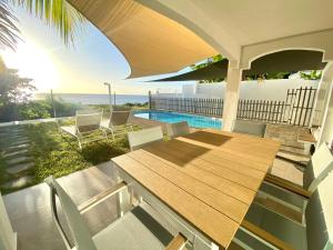 弗利康弗拉克Solara West - Private Pool and Seafront的一个带桌椅的门廊和一个游泳池