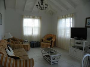 a living room with couches and a flat screen tv at AnnJenn Apartments in Christ Church