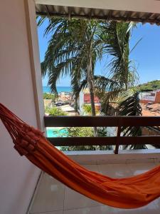 a hammock on a balcony with a view of the beach at Pousada Praiana Pipa in Pipa +21 photos