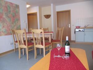 una sala da pranzo con tavolo e una bottiglia di vino di Ferienanlage Harzfreunde ad Allrode