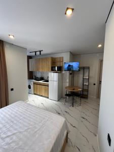 a bedroom with a bed and a table and a kitchen at Saba Guest House in Ureki