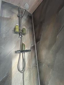 a shower with a hose attached to a wall at Danu Resort in Castlerock +37 photos
