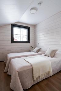 zwei Betten in einem Zimmer mit Fenster in der Unterkunft Auroralevi Sointuilevi B63, Central, Sauna, Ski nearby in Levi