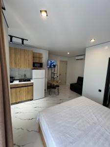 a bedroom with a white bed and a kitchen at Saba Guest House in Ureki +37 photos