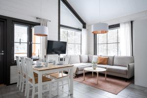 a living room with a couch and a table at Auroralevi Suites Sointuilevi, Log Cabin, Central, Sauna, 2 ski passes included in Levi