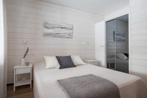 ein Schlafzimmer mit einem Bett und einer ebenerdigen Dusche in der Unterkunft Auroralevi Sointuilevi B63, Central, Sauna, Ski nearby in Levi