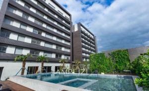 a swimming pool in front of a building at Linked Ampllizi in Porto Alegre