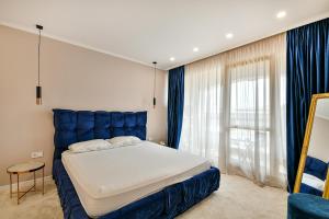 una camera con un letto blu e una grande finestra di Carpe vita 1BR Pool & Parking a Varna Altre 10 foto