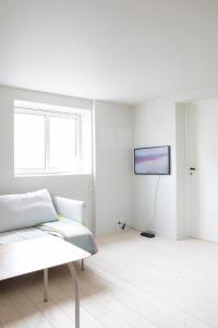 a white room with a couch and a tv at Ny og moderne leilighet i Bodø Sentrum! in Bodø