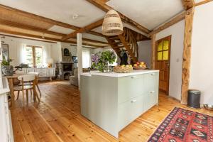 a kitchen with white cabinets and a wooden floor at Cisza żurawi in Piszewo
