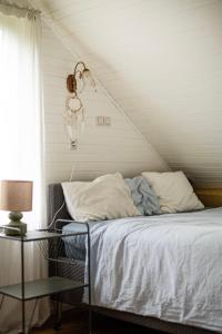 a bed with white sheets and a lamp in a room at Cisza żurawi in Piszewo