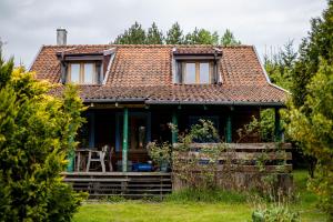 a small house with a porch and a roof at Cisza żurawi in Piszewo