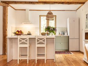 a kitchen with white counters and a white refrigerator at Cisza żurawi in Piszewo +14 photos