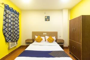 a bedroom with a bed with yellow and blue at Hotel O Prabir Residency Inn in Urāli