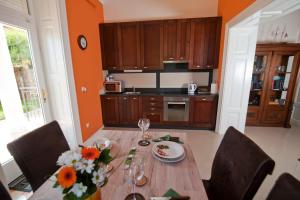 a kitchen with a wooden table with flowers on it at Apartman Isadora in Opatija