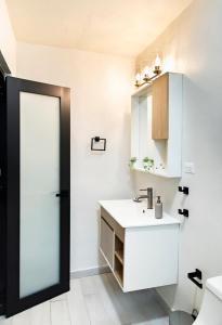 a white bathroom with a sink and a mirror at Fully Renovated Beachfront 2 Bedroom Unit 2 1 Bath Prime Dorado Location in Dorado