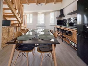 リバデオにあるApartamentos Ribadeoのキッチンにテーブルと椅子があるダイニングルーム