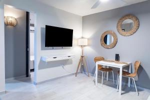 un salon avec une télévision, une table et des chaises dans l'établissement Fully Renovated Beachfront 2 Bedroom Unit 4 1 Bath Prime Dorado Location, à Dorado 15 autres photos