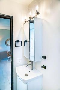 une salle de bains avec un lavabo blanc et un miroir dans l'établissement Fully Renovated Beachfront 2 Bedroom Unit 4 1 Bath Prime Dorado Location, à Dorado