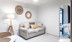 a white living room with a chair and a mirror at Fully Renovated Beachfront Family Building 1 8 Bedrooms 4 Baths Prime Dorado Location in Dorado