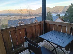 a table and a chair on a balcony with a view at Chalet vue lac à 200 mètres des remontées in Les Angles